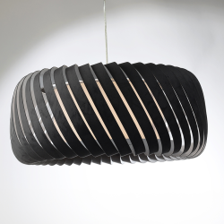 Vue sur la suspension CLYDE design en lamelles ajourées velours coloris anthracite, allumée et installée sur fond neutre.