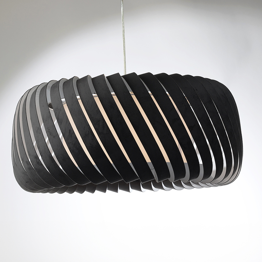 Vue sur la suspension CLYDE design en lamelles ajourées velours coloris anthracite, allumée et installée sur fond neutre.