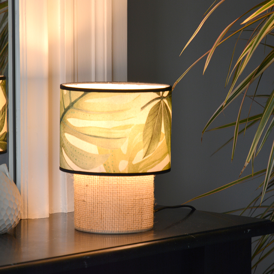 Lampe TABATA allumée, diffusant une lumière douce à travers son abat-jour à motif jungle Camboya