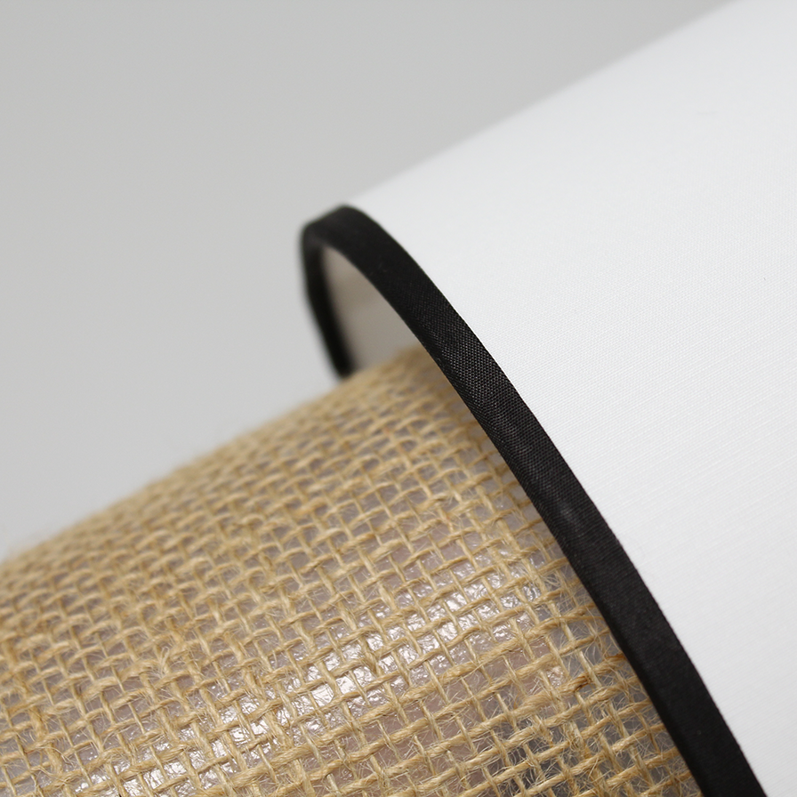 Détail de l’abat-jour cylindrique en coton blanc avec liseré noir de la lampe TABATA
