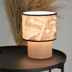 Lampe TABATA jungle allumée diffusant une lumière chaleureuse à travers les motifs tropicaux