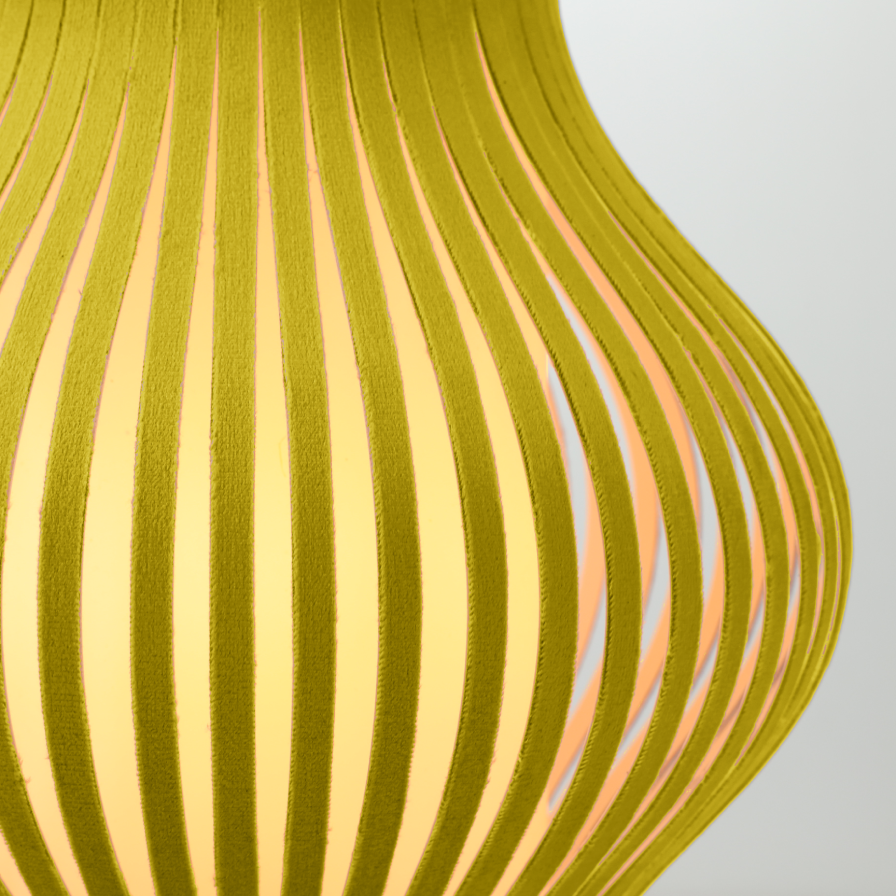 Gros plan sur la forme ondulée de la lampe Onion allumée, lampe de table en velours jaune design