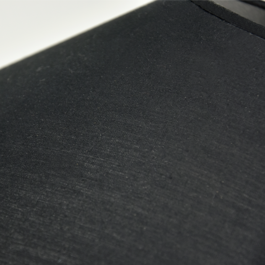Zoom sur l’abat-jour en coton noir – Gros plan sur la texture du coton noir soulignant l’élégance sobre de la lampe.