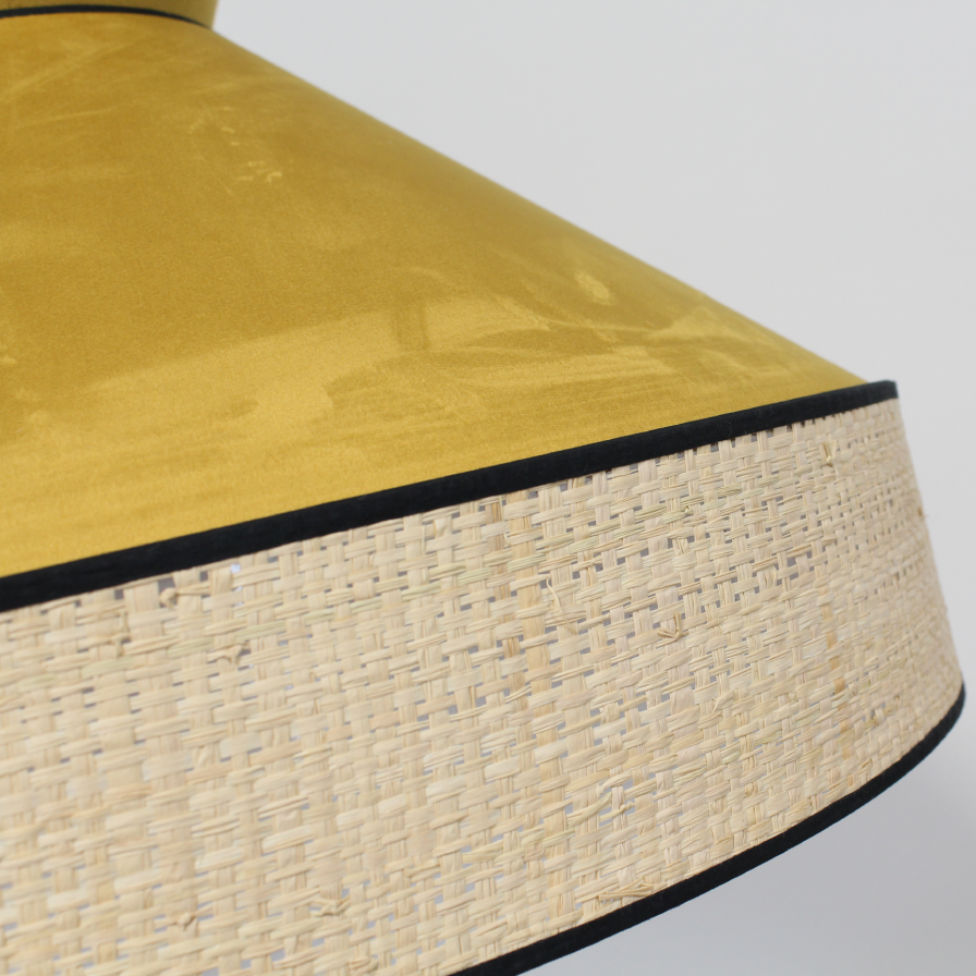Zoom sur la suspension GATSBY en velours jaune pécan et son disque en rotin, parfaite pour une atmosphère chaleureuse.